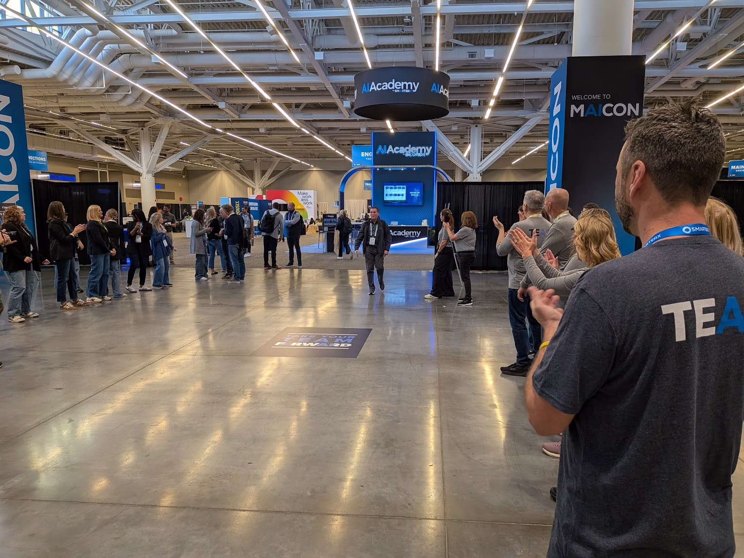 The MAICON team applauding attendees on the convention floor